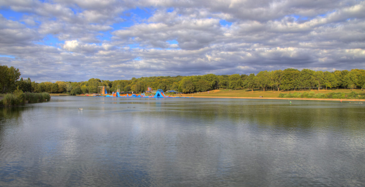 Green meadows and trees along the river in Fairlands Valley Park, Stevenage